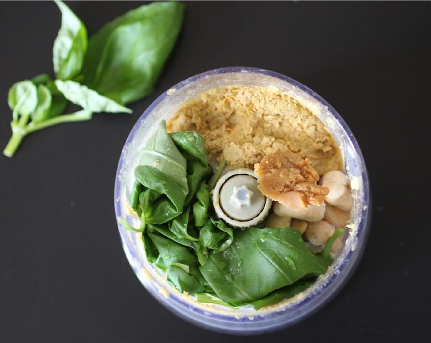 step 2 Add the Fresh Basil (1/2 cup), drained cashews, Garlic (1 clove), Nutritional Yeast (4 Tbsp), White Miso Paste (1 tsp), Water (1 Tbsp), juice from Lemon (1) and Salt (1 pinch) to a food processor.