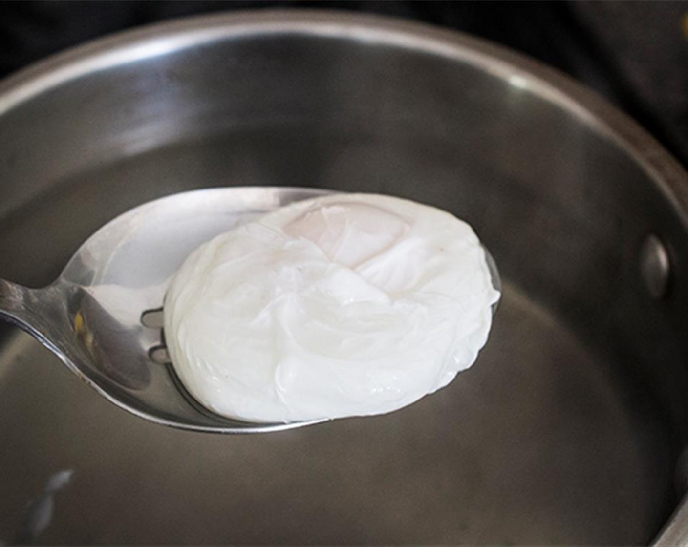 step 11 Do this again with the second egg. Cover the pan with a lid and let it cook for 3 minutes (no peeking!) Once cooked, use a slotted spoon to gently lift the eggs out of the water. Transfer to a paper towel to drain.