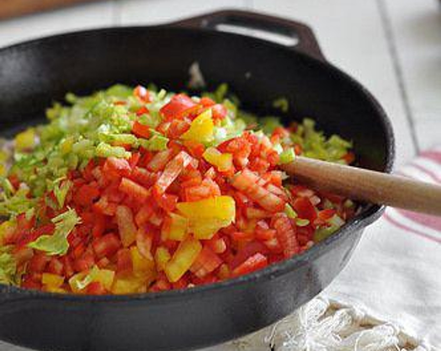 step 5 Heat a skillet over medium high heat. Add the Unsalted Butter (4 Tbsp),  When melted, add the chopped small red onion, red bell pepper, yellow bell pepper, garlic cloves, celery, parsley, and caper.