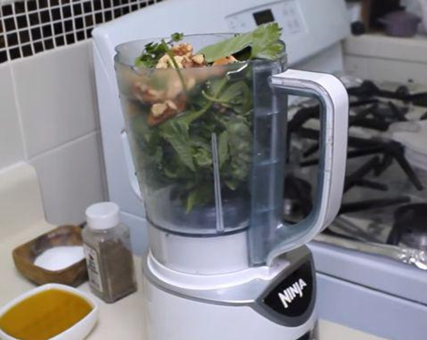 step 1 In a food processor, or a blender if none are available, add the fresh Fresh Basil (3 cups), fresh Fresh Parsley (1 cup), Walnuts (4 Tbsp), Garlic (3 cloves), and Grated Parmesan Cheese (4 Tbsp). Zest and juice the Lemon (1) into the processor and turn it on.