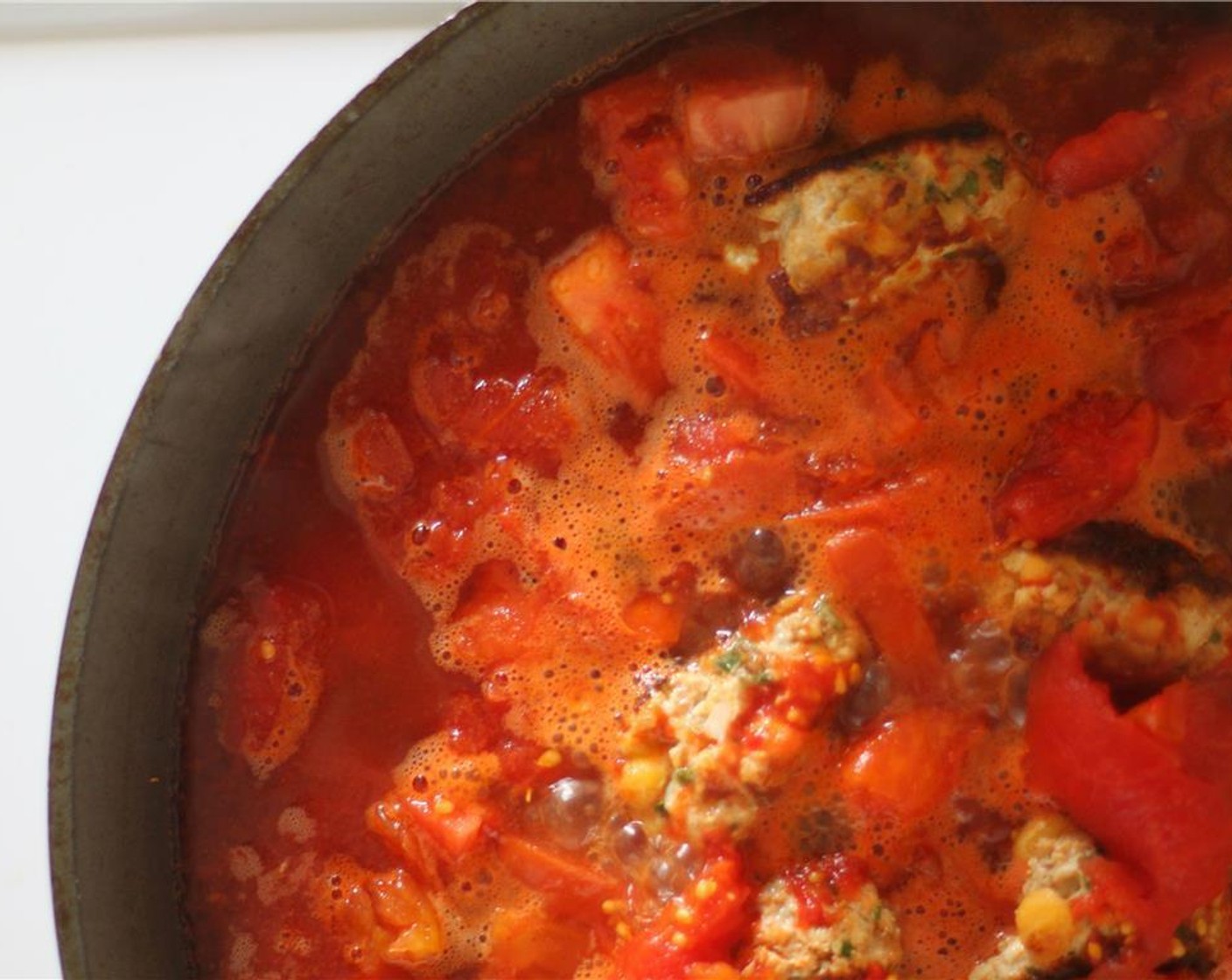 step 4 Turn down to medium-high heat and add the Roma Tomatoes (2). Allow to soften for a few minutes, and then add the Whole Peeled Tomatoes (1 can) and Chicken Stock (1 cup). This should almost completely cover the meatballs.
