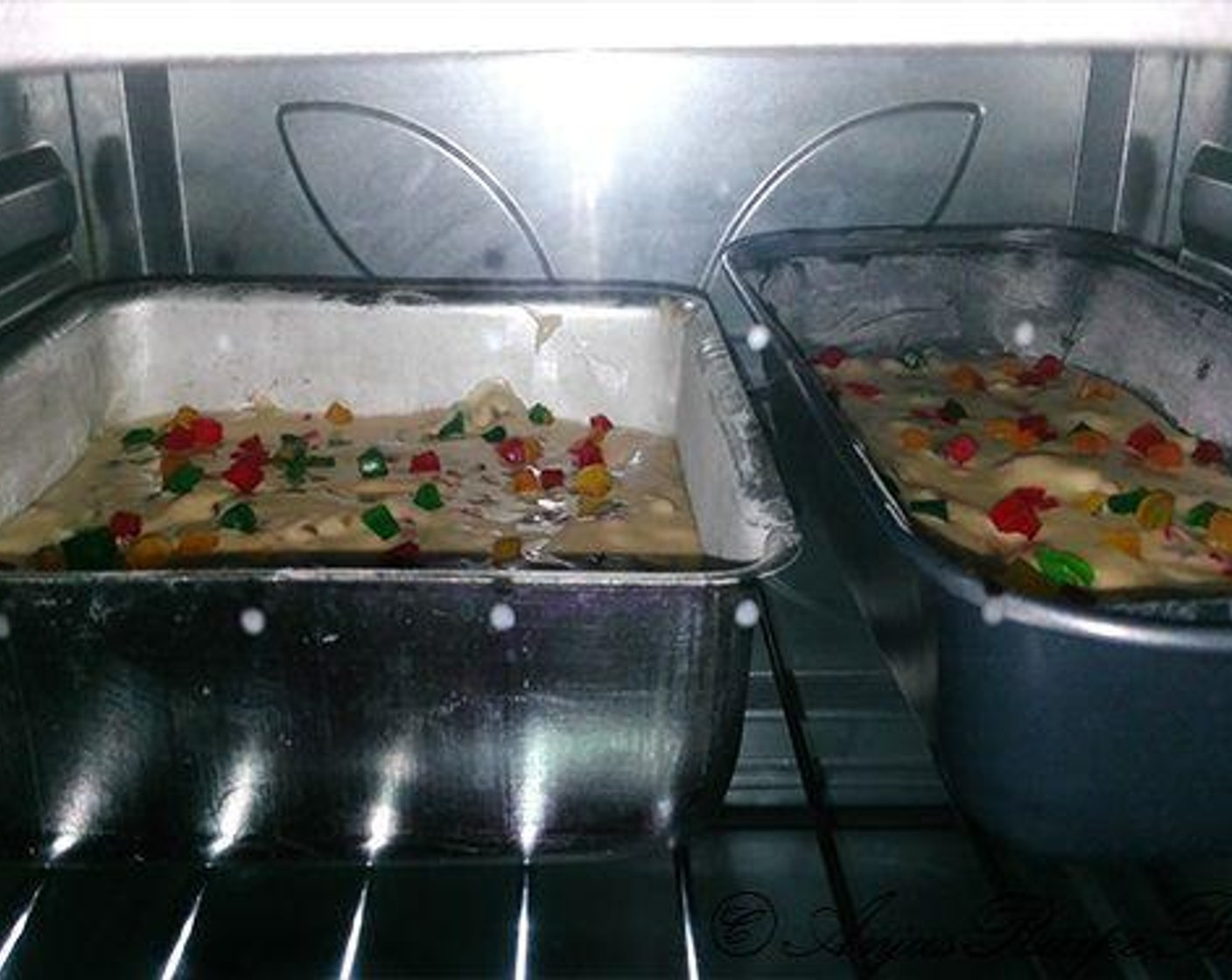 step 7 Pour the batter into the prepared cake tin. I have used two small cake tins. Sprinkle a few tutti frutti on top. Place the cake tins in the oven and bake for 30 to 35 minutes.