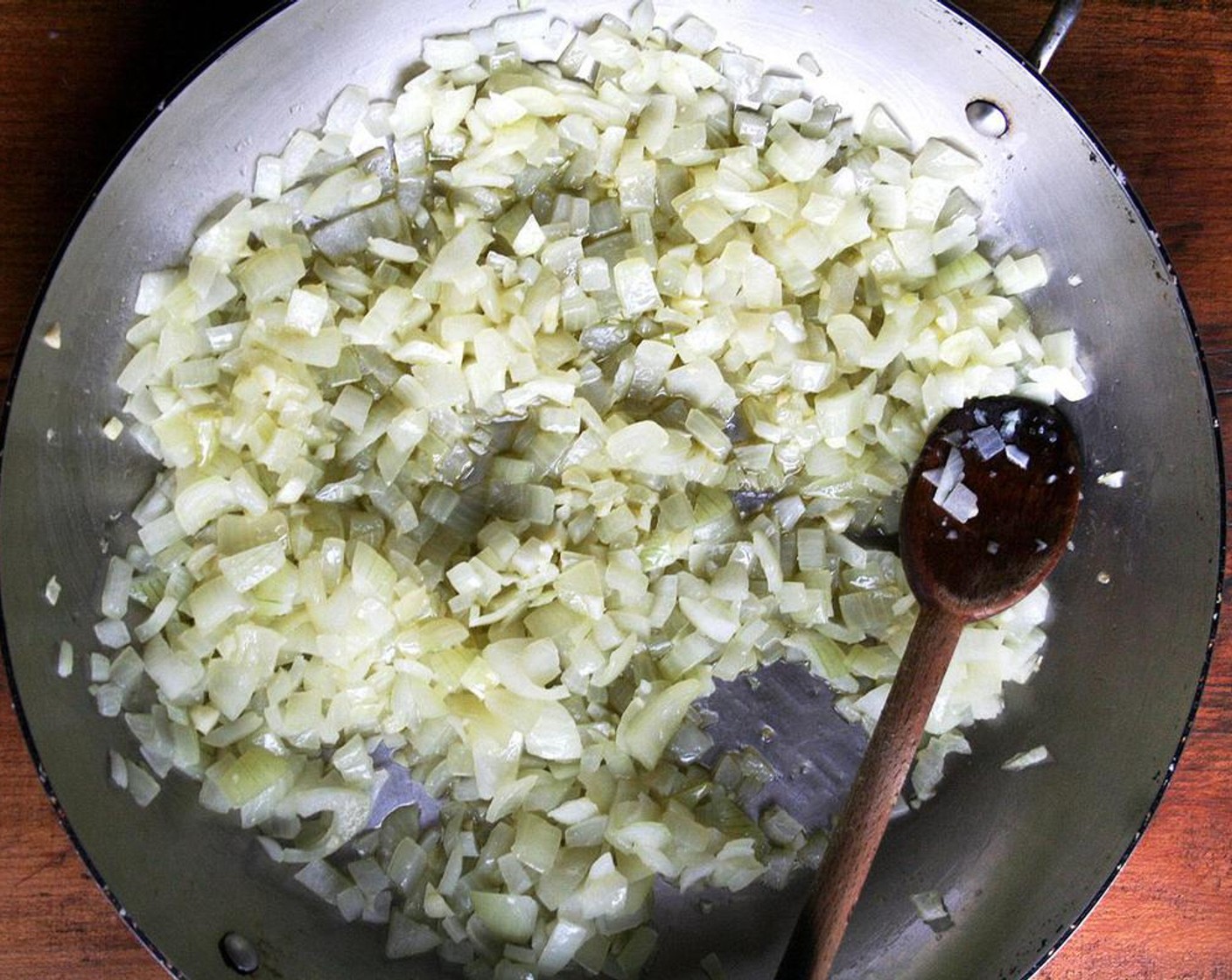 step 2 Heat the Olive Oil (4 Tbsp) in a large oven proof sauté pan over medium heat, add the Spanish Onion (1) and Garlic (3 cloves) and cook for about 5 minutes until translucent.