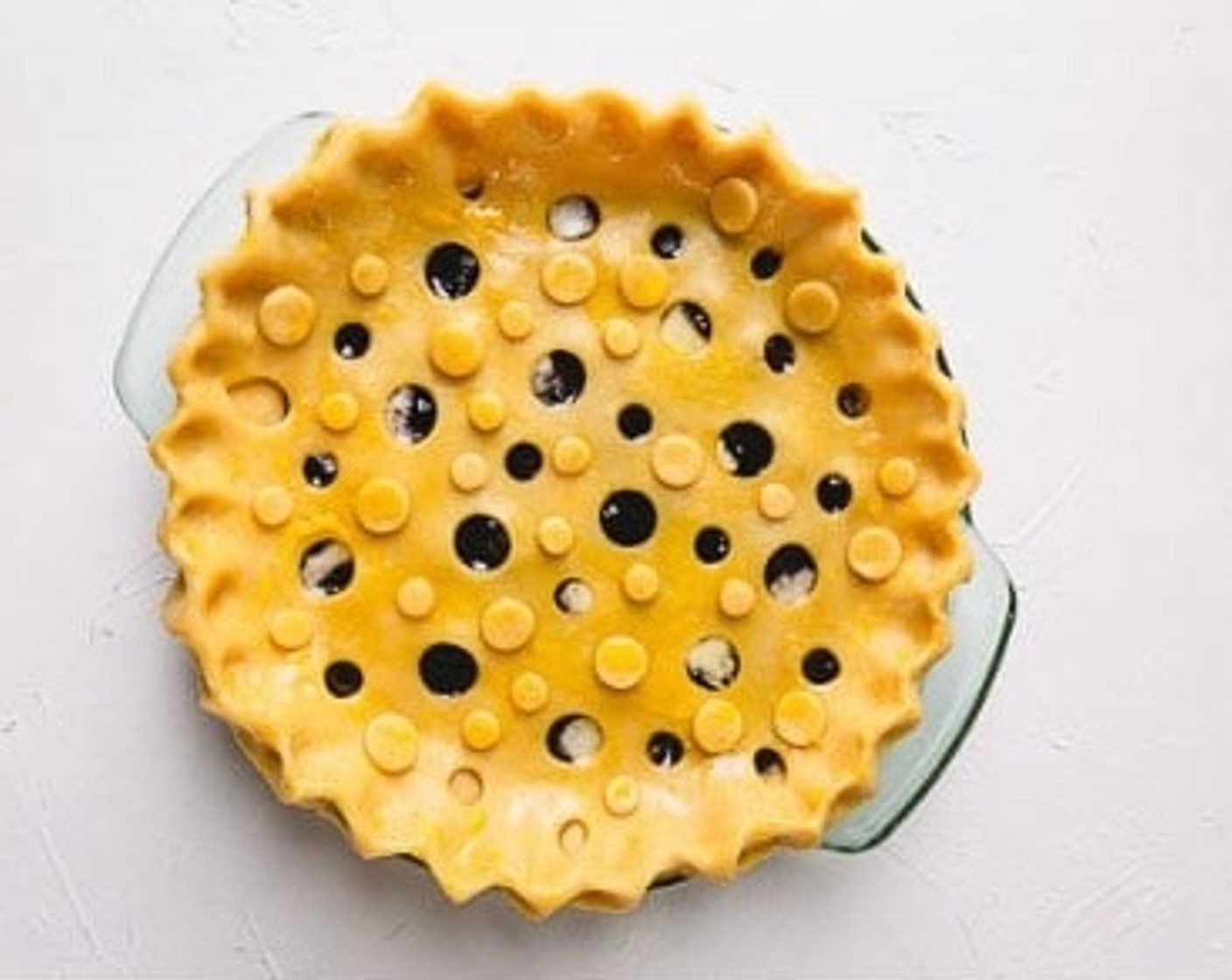 step 9 Pour the cherry filling into the pie pan. Dot with butter cubes and cover with top crust. Cut the extra dough hanging over the edges. Make 3 small slits in the middle and brush some heavy cream over the top crust.