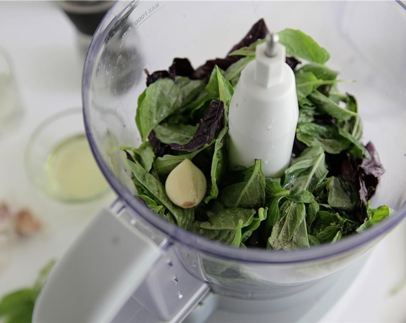 step 5 While the potatoes roasting, prepare salad. Put Fresh Basil Leaf (1 cup), Garlic (1 clove) Kosher Salt (to taste), Ground Black Pepper (1/4 tsp), Olive Oil (4 Tbsp), and Champagne Vinegar (2 Tbsp) in a small food processor.
