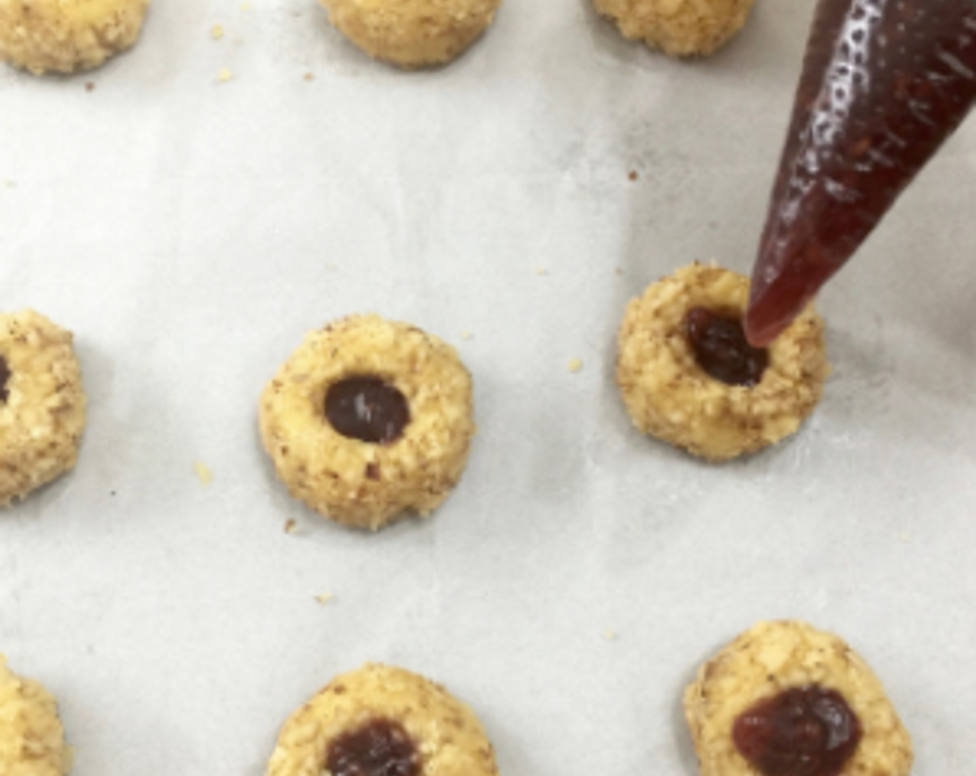 step 24 Fill each indentation with the raspberry jam using a small spoon or a filled piping bag. Do not overfill, just a little above the indentation so it will not flow over the sides when baked.