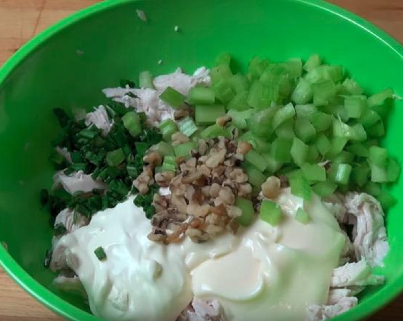 step 3 Into the mixing bowl with the chicken, add Mayonnaise (1/2 cup), Sour Cream (2 Tbsp), Fresh Chives (2 Tbsp), Celery (2 stalks) and Walnuts (2 Tbsp). Mix to combine.
