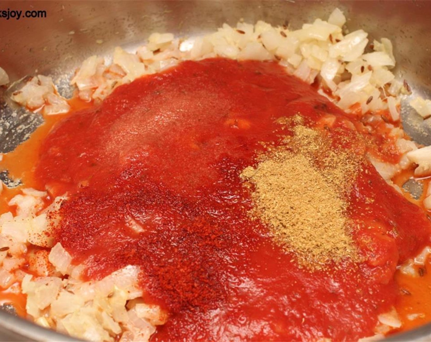 step 8 When the onion are cooked, add the Tomato Sauce (2 cups), Salt (to taste), Chili Powder (1/2 tsp), and Ground Coriander (2 tsp). Simmer for 10 minutes.