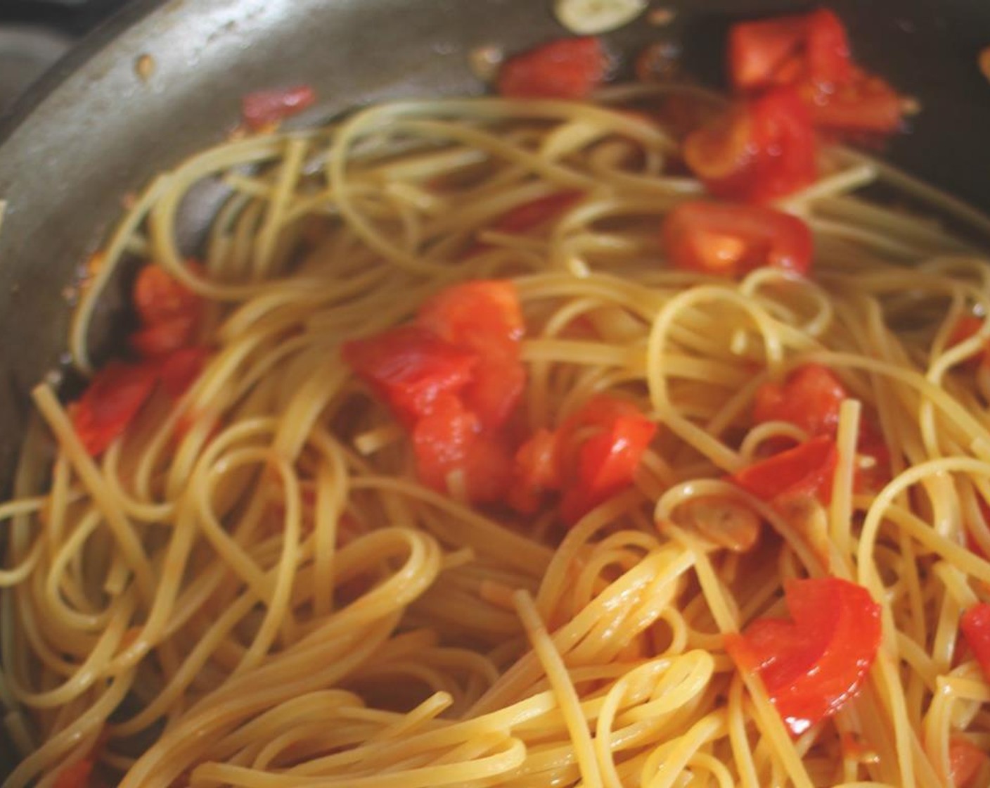 step 6 Your pasta should be about halfway cooked. Turn the pan to high heat and add the pasta right from the pot. Don't drain the pasta first. You'll continue to cook it in the garlic, oil, and tomatoes until it is al dente.