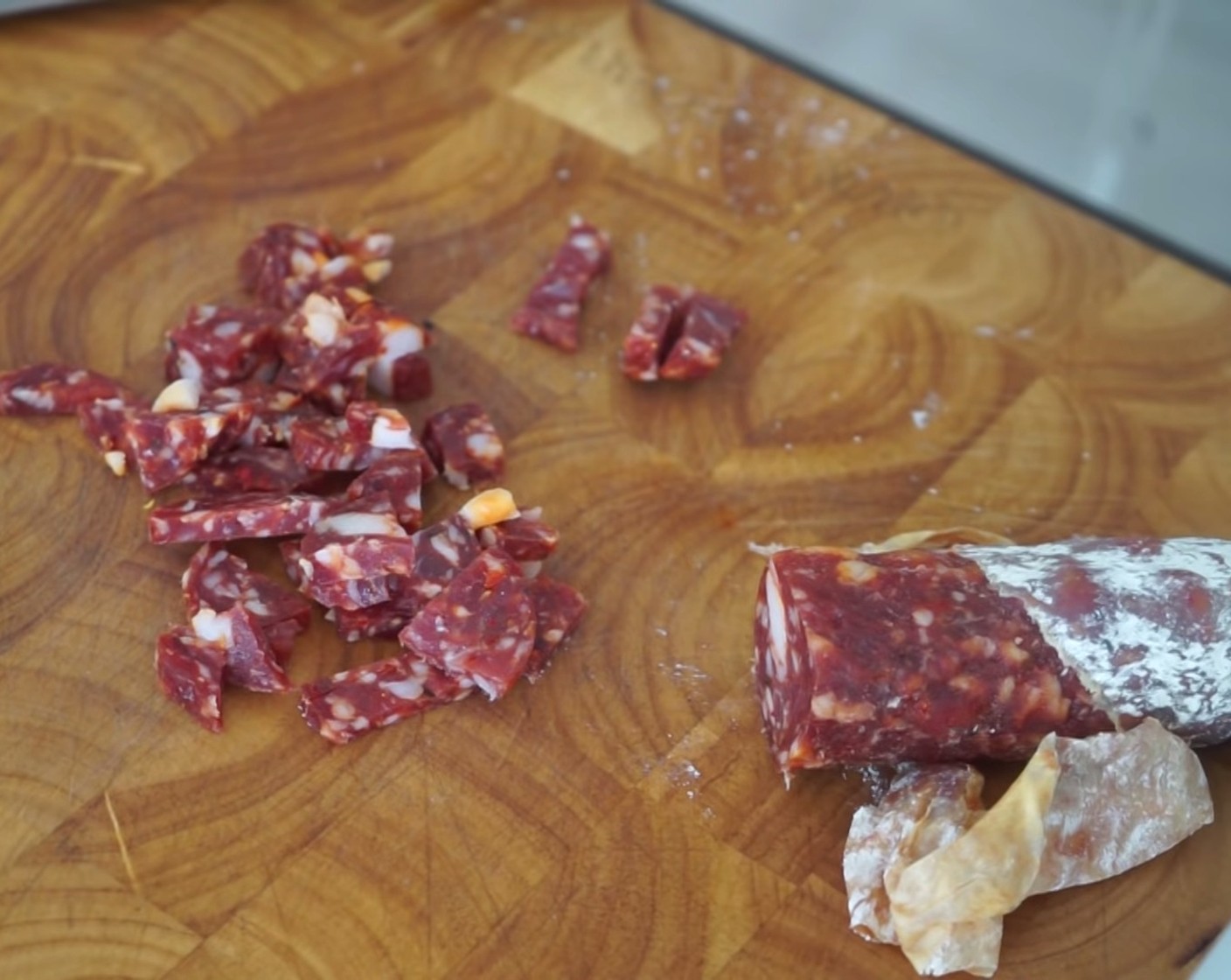 step 17 Next, peel the skin off your Salami (1) and cut it into slices (not too thin) before chopping it into pieces and put them to the side.