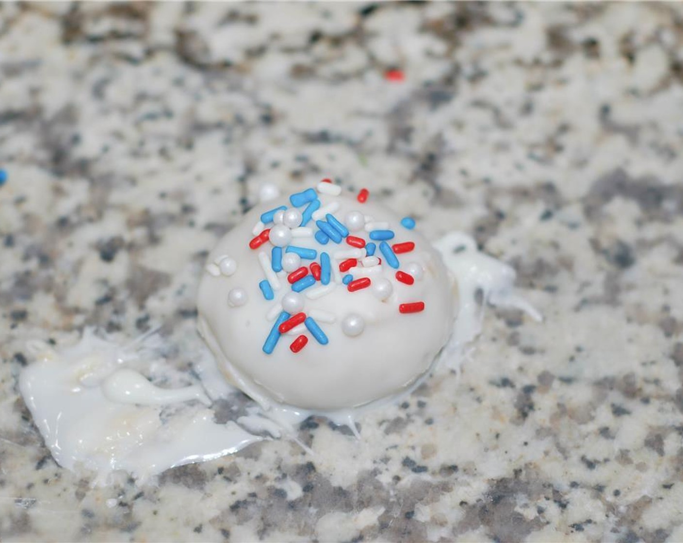 step 8 Place the balls on wax paper, and sprinkle Red, White, and Blue Sprinkles (1/2 cup) and White Sugar Pearl Sprinkles (4 Tbsp). Let sit to harden.