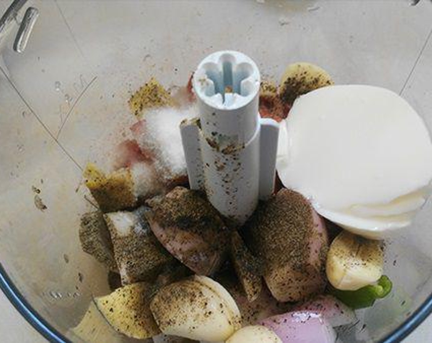 step 2 Grind Onion (1), Fresh Ginger (1/2 in), Garlic (3 cloves), Green Chili Peppers (2), Tomato (1), Yogurt (1 Tbsp), the juice from Lemon (1), Ground Black Pepper (1/2 tsp), Arabic Masala (2 tsp), and Salt (to taste) into a fine paste.