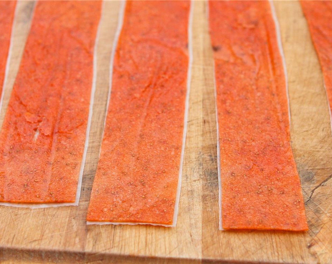 step 6 Remove from plastic wrap and place firmly on pieces of wax paper on a flat work surface. Using a scissors, trim the edges and cut into 1-to 1.5-inch strips.