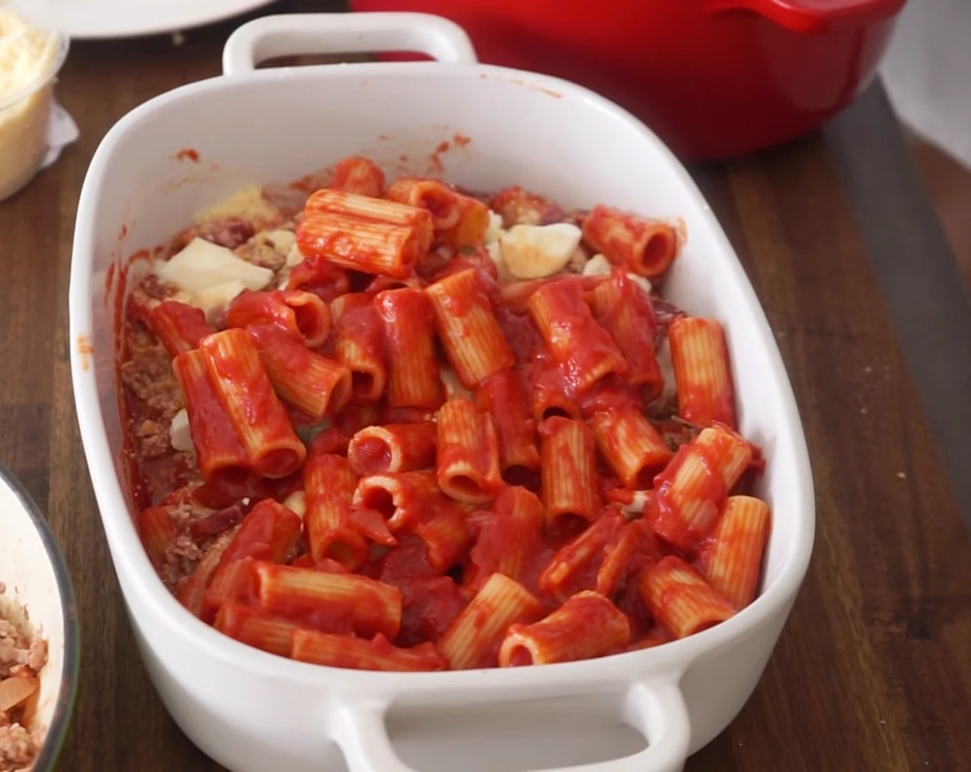 step 20 Next, add the pasta, smoothing it out to cover each edge, before adding a few spoonfuls of mince, pieces of both types of mozzarella, a sprinkle of Pecorino Romano Cheese (3/4 cup), a handful of salami, and eggs.