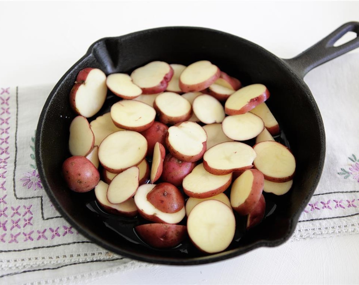 step 2 Place New Potatoes (2 1/4 cups) and Olive Oil (2 tsp) in a 10-inch cast-iron skillet, season with Kosher Salt (1/2 tsp), and toss to combine.