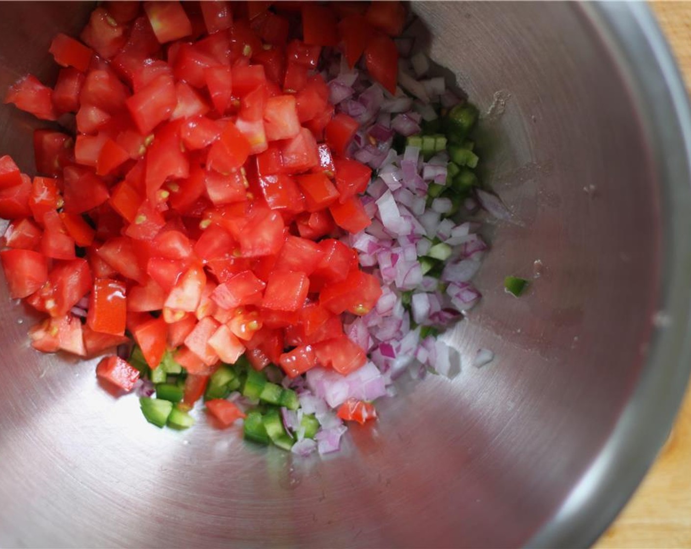 step 3 While the corn roasts, prep the vegetables. Mix the Jalapeño Pepper (1), Red Onion (1/2), Roma Tomato (1), and Red Chili Peppers (4 Tbsp). Add the Fresh Cilantro (4 Tbsp).