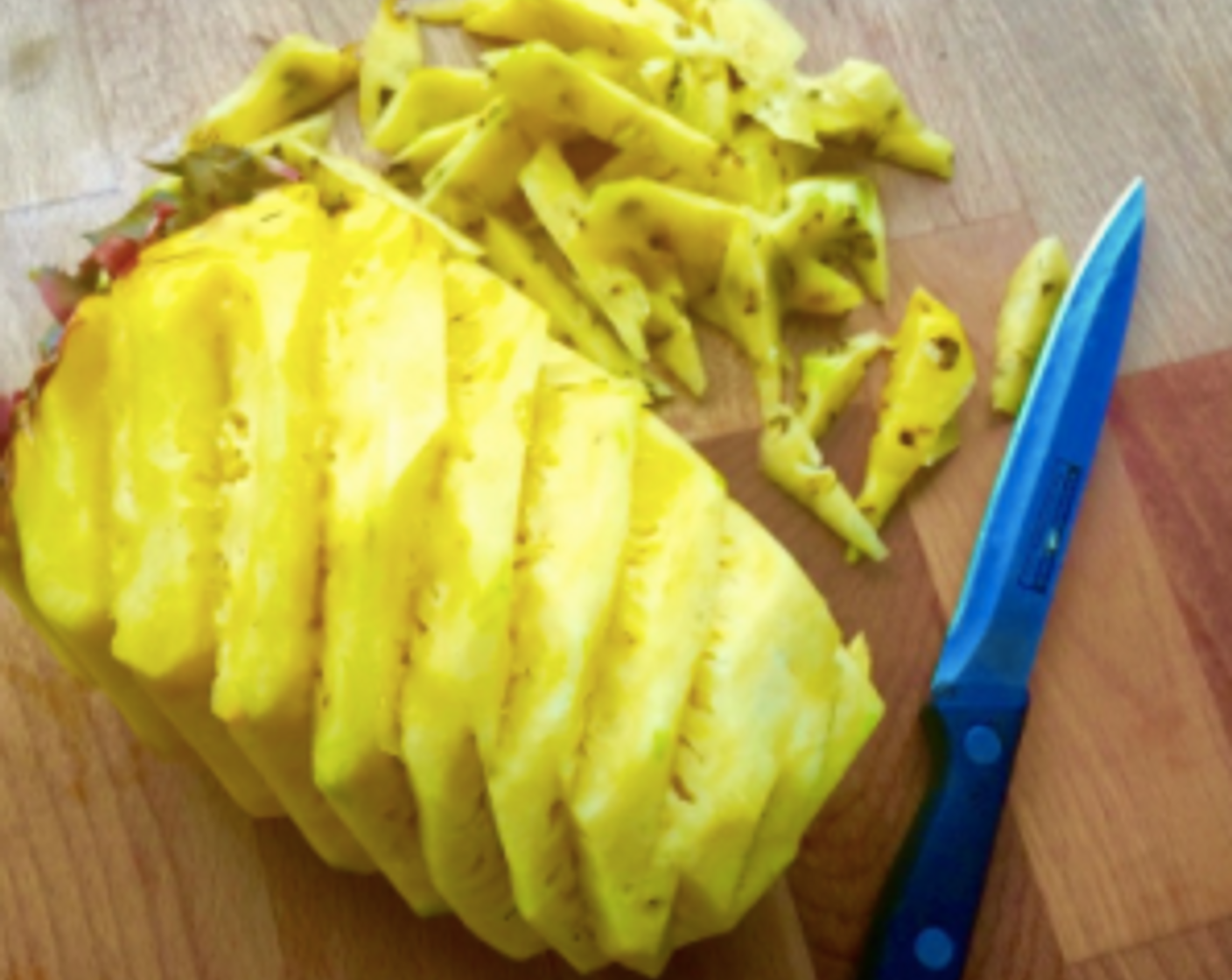 step 7 Continue to work around the pineapple to carefully remove the "eyes" of the fruit.