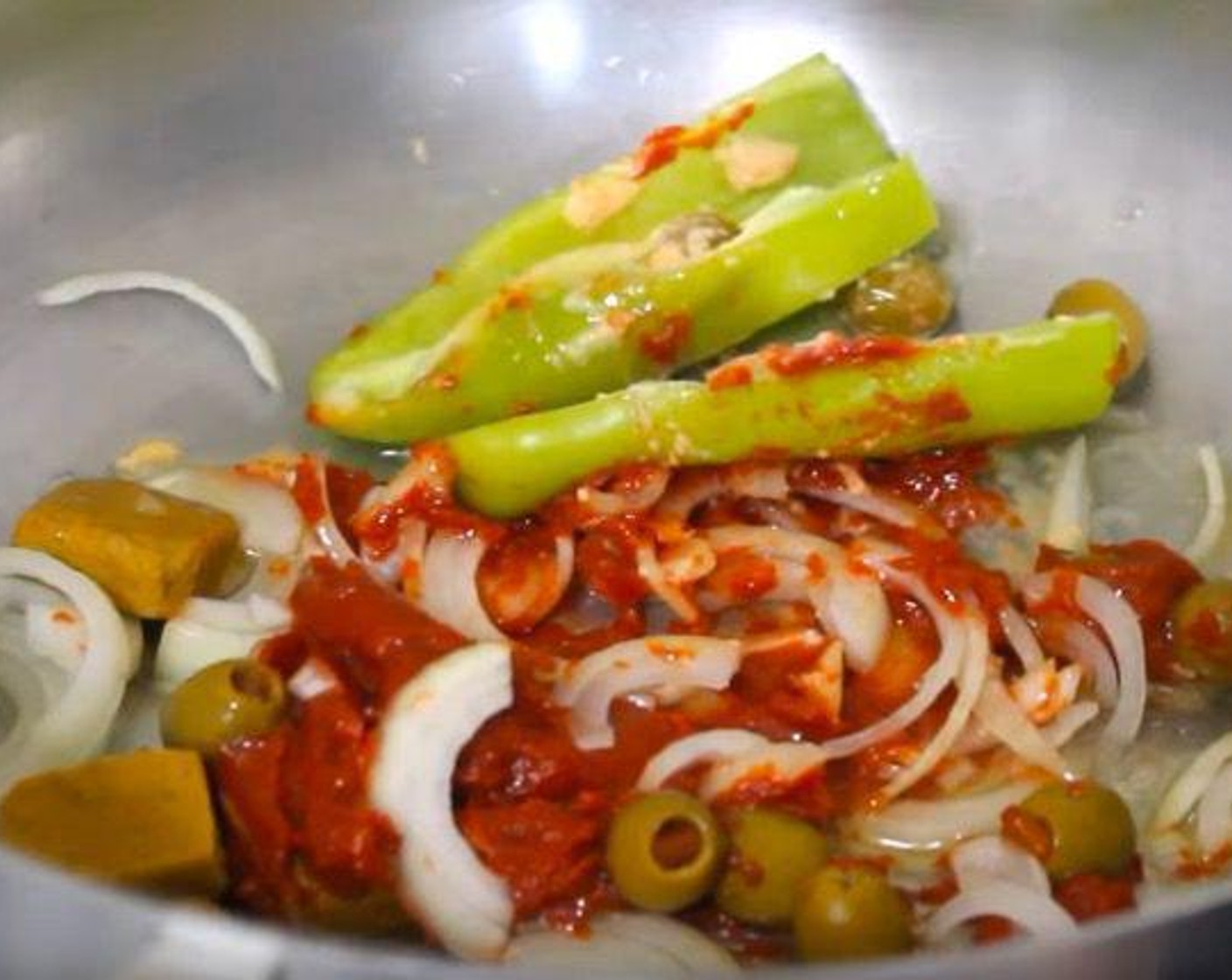 step 1 In a sauce pan, add the Oil (3 Tbsp), Onion (1), Cubanelle Pepper (1), Garlic Paste (1 tsp), Chicken Bouillon Cubes (3), Distilled White Vinegar (1 tsp), Tomato Paste (4 Tbsp), and Olives (4 Tbsp). Cook until the chicken bouillon cubes have dissolved.