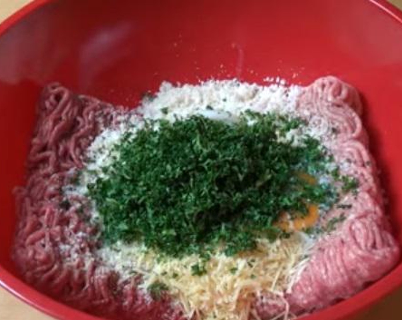 step 1 Into a mixing bowl, add in the Ground Beef (1.1 lb), Pork (1.1 lb), Garlic Powder (1 tsp), Breadcrumbs (1 cup), Parmesan Cheese (4 Tbsp), Eggs (2), Milk (1/2 cup), Fresh Parsley (1/2 cup), Salt (to taste), and Ground Black Pepper (to taste). Using your hands mix everything together.