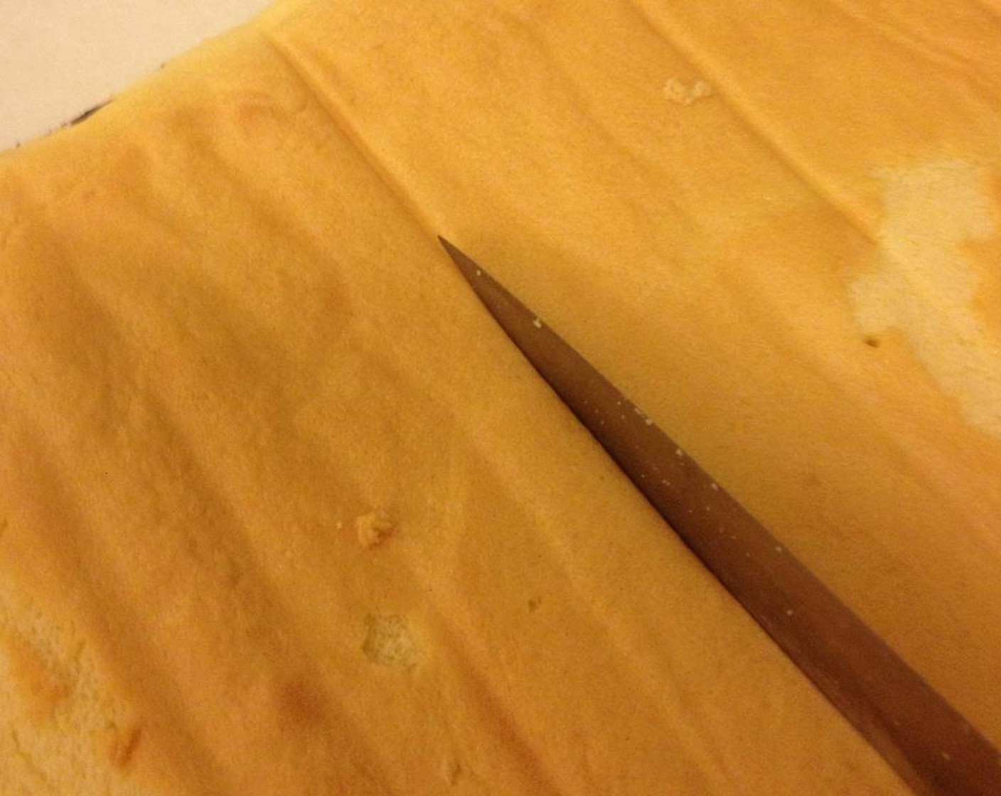 step 14 Once the cake has completely cooled down, use the back of the knife to lightly press a line on the cake which make it easier to roll later.