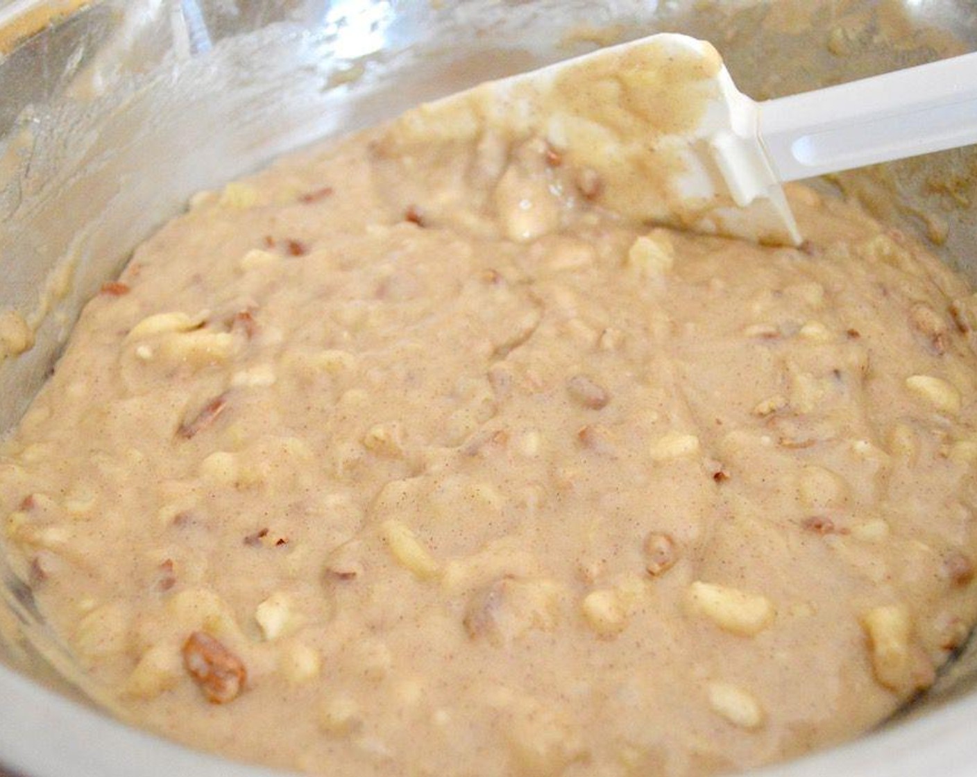 step 4 Stir the Bananas (4), Crushed Pineapple in 100% Pineapple Juice (1 cup), Vegetable Oil (1 cup), Eggs (2), Vanilla Extract (1 tsp), and Chopped Pecans (1 cup) together in another bowl thoroughly, then pour it into the bowl of dry ingredients.