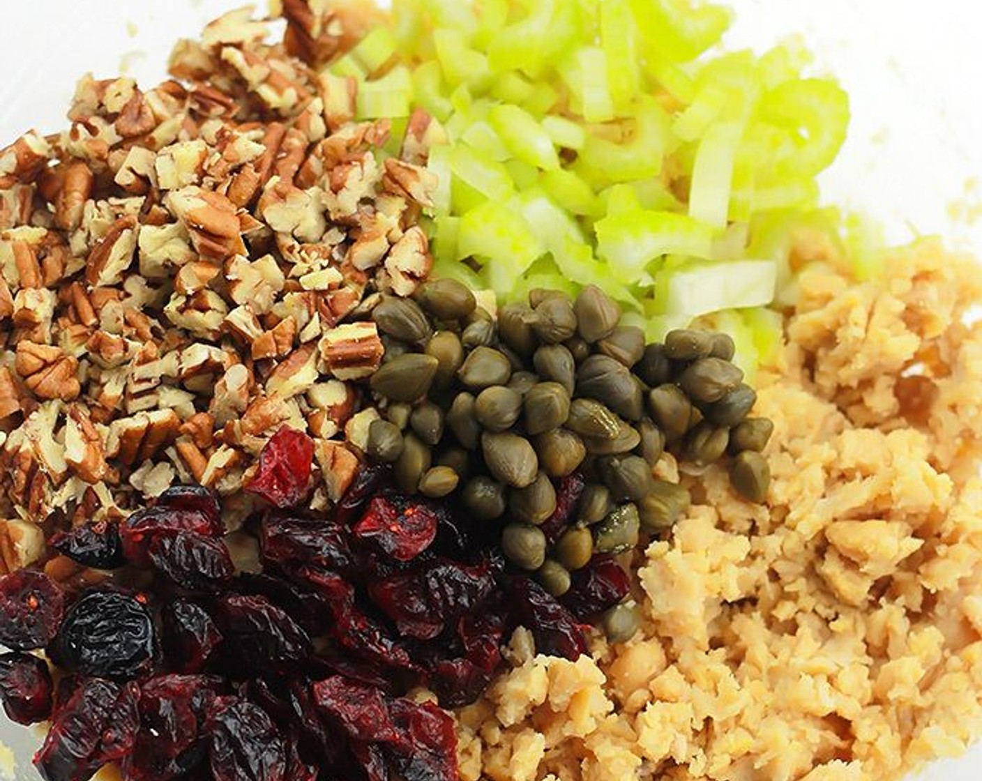 step 2 Add in the Celery (1/2 cup), Chopped Pecans (1/2 cup), Dried Cranberries (1/2 cup), Capers (1 Tbsp), Garlic Powder (1 tsp), and Vegan Mayonnaise (2 Tbsp). Add in more mayo for a creamier salad. Season with Salt (to taste) and Ground Black Pepper (to taste).