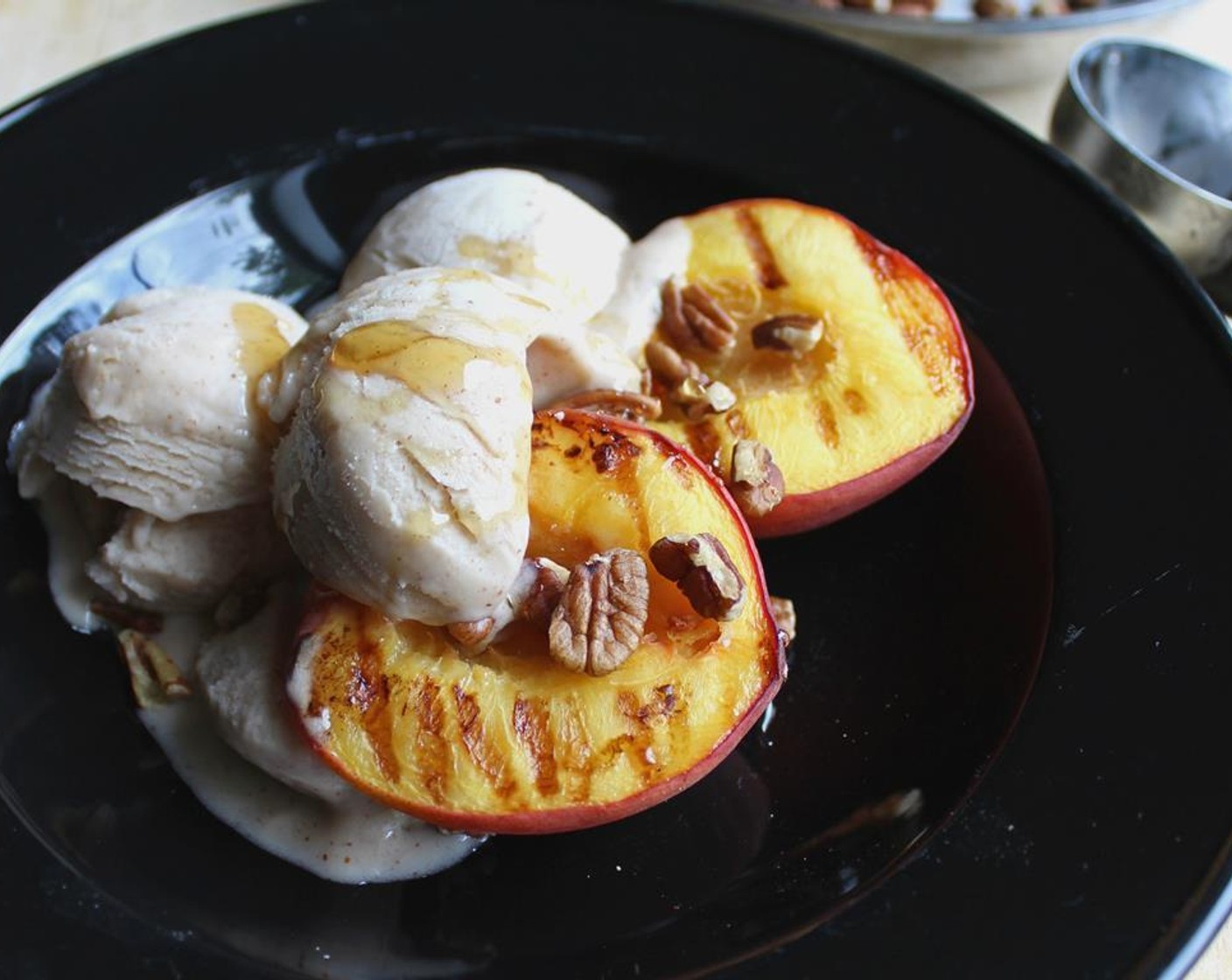 step 5 Fill your bowl with grilled peaches, a couple scoops of Vanilla Ice Cream (2 cups), a drizzle of Honey (4 Tbsp) and some Pecans (4 Tbsp).