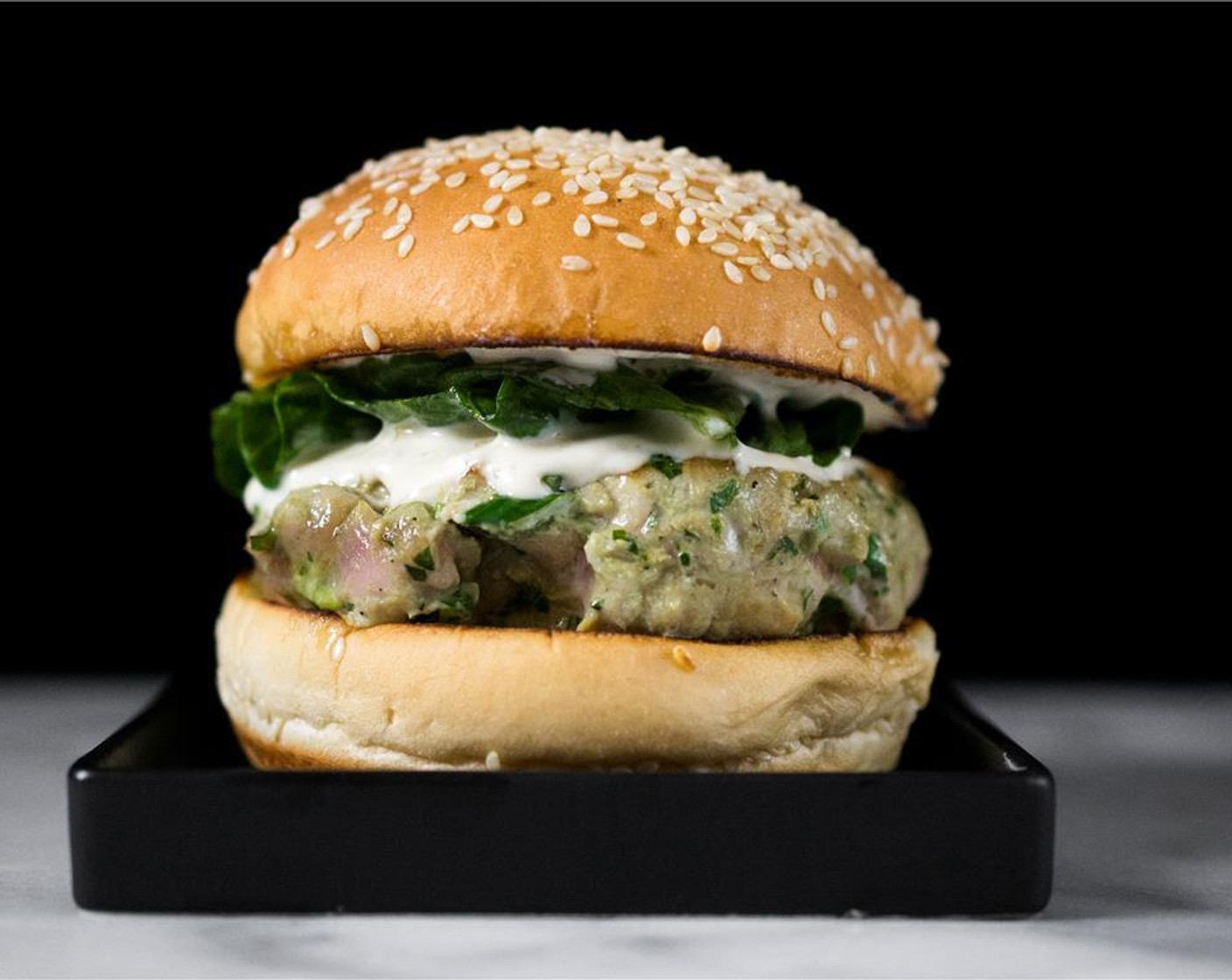 step 9 To assemble, place the burgers on the bun bottoms. Top each with wasabi mayo and dressed lettuce. Cover each burger with the bun tops and serve immediately.