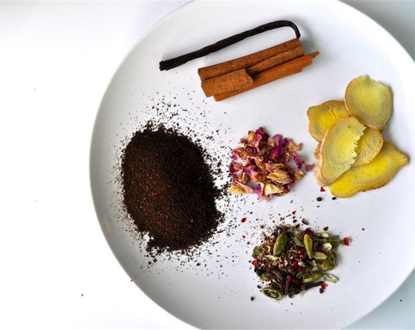 step 3 Put Cinnamon Sticks (2), vanilla, fresh Fresh Ginger (5 slices), Brown Sugar (1 Tbsp), Dried Pink Rose Petals (1 tsp), crushed peppercorns, cloves, cardamom, Black Tea (4 bags) and Milk (5 cups) in a small pot and bring to a simmer.