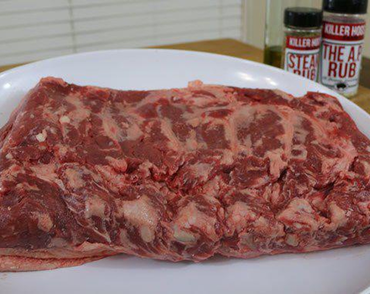 step 1 Remove the New York Strip Steak (1) from the cryovac packaging and blot off any excess liquid with a paper towel. Place the roast on a large platter or prepping surface and coat the outside with Olive Oil (as needed). Season with Salt (to taste), Ground Black Pepper (to taste), and Garlic Powder (to taste).