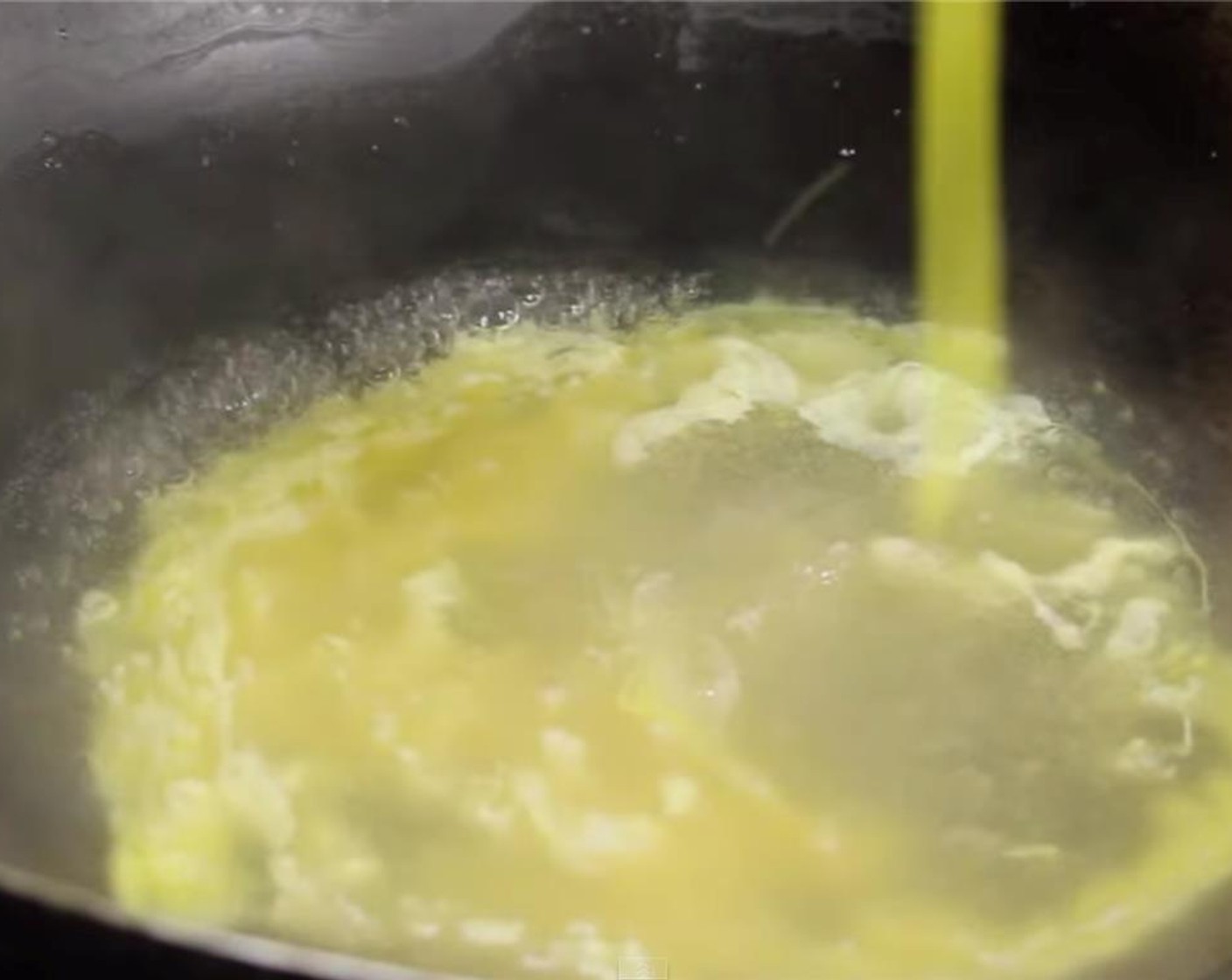 step 6 Drizzle the egg in the heated broth in a clockwise direction. Once there is a little bit of egg poured inside turn on the heat to medium and continue to drizzle the egg in the same direction.