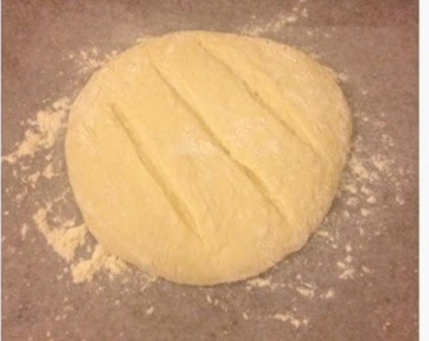 step 4 Transfer onto a floured surface, and gently fold the corner of the dough into the middle. Form a round smooth dough. Line a tray with parchment paper with flour on it. Transfer the dough onto it. Let the dough rise for an hour.