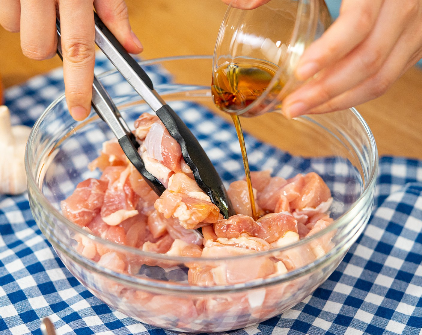step 1 Cut Chicken Thigh (1 lb) into bite-size pieces (around 1-inch). Add to a bowl with the Sesame Oil (1 tsp). Toss until well coated and set aside.
