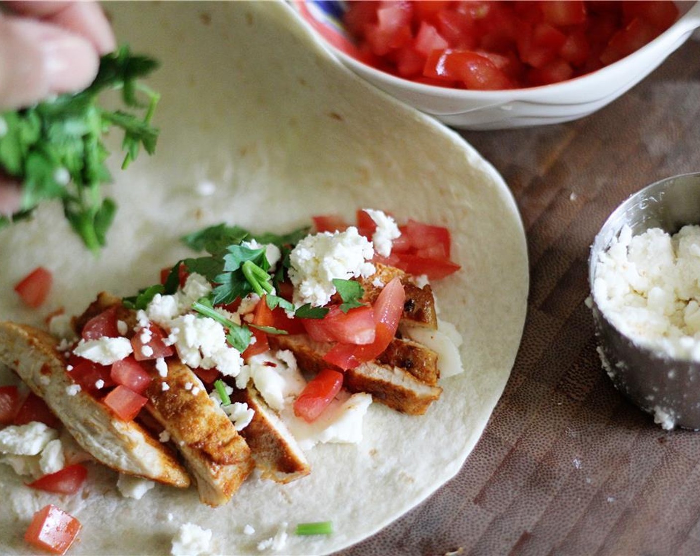 step 3 Place Tortillas (2) on a flat surface; divide the chicken, Tomato (1), Shredded Mozzarella Cheese (1/2 cup), Feta Cheese (1/3 cup), and Fresh Parsley (1/3 cup) between both tortillas.
