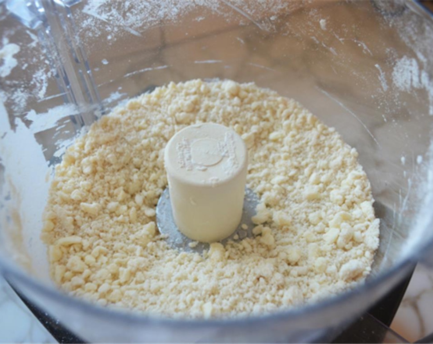step 3 Add half of the Water (4 Tbsp) and pulse a few times to incorporate. Add the remaining water and pulse until the mixture is just evenly moistened and very crumbly.