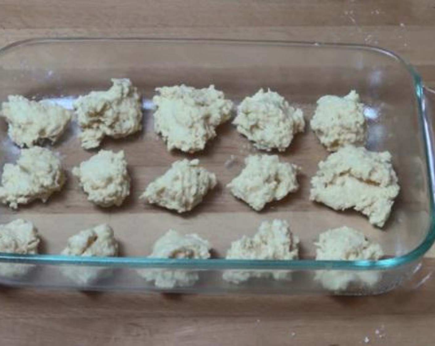 step 2 Roughly divide your dough into 15 dumplings, and line them up on a greased baking tray.