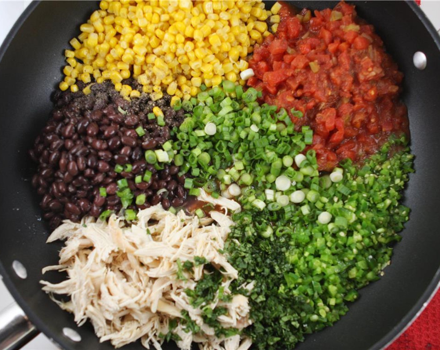 step 4 Add the Chicken (1 cup), Corn (1 can), Black Beans (1 can), Diced Tomatoes (1 can), Scallion (1 bunch), Fresh Cilantro (4 Tbsp), juice from the Lime (1), Salt (to taste), and Ground Black Pepper (to taste) to the skillet. Cook mixture over medium-low heat for about 5 minutes, stirring frequently.