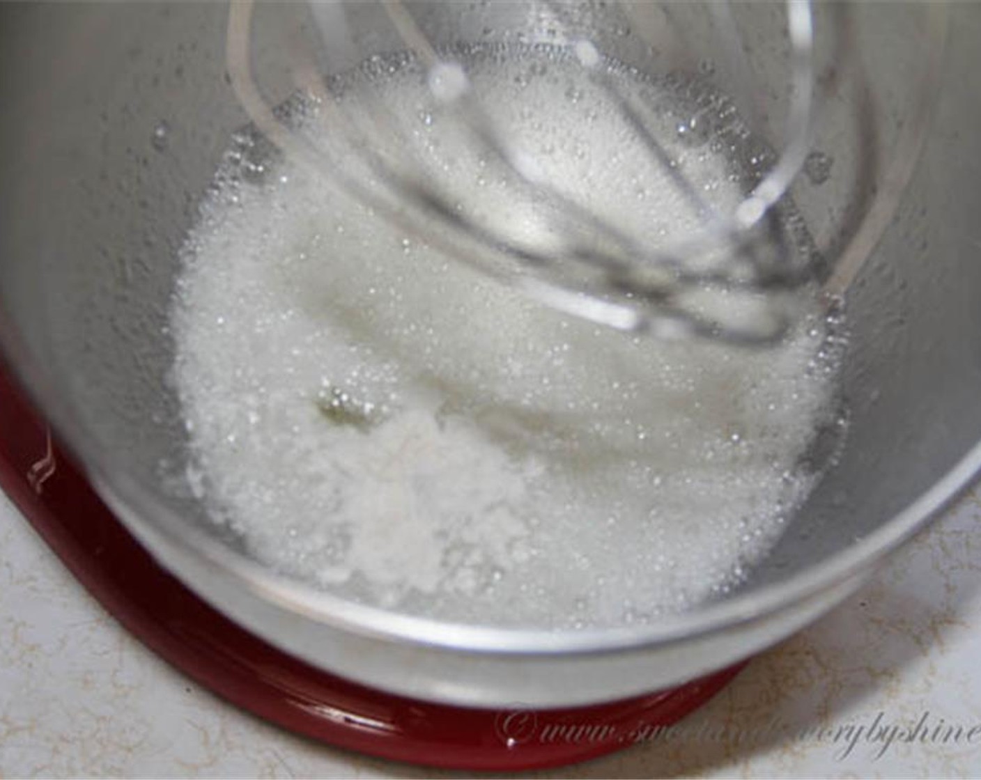 step 6 When the egg whites get pretty white, stir in the remaining sugar one tablespoon at a time. Continue to beat on high speed until stiff peaks form. Add Orange (1 Tbsp) and Pure Vanilla Extract (2 tsp).