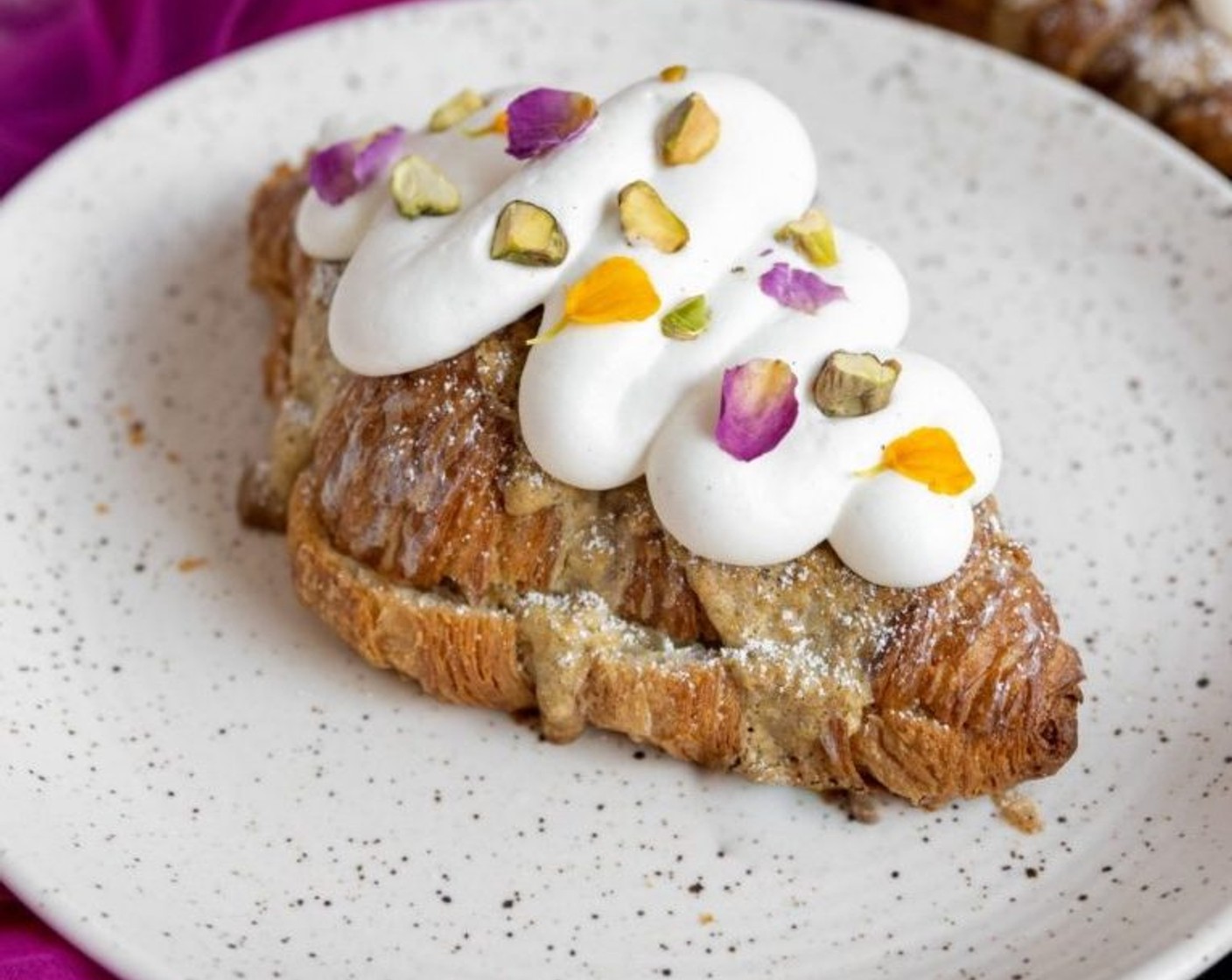 step 10 Once the croissants are completely cool, dust with some powdered sugar, pipe on the heavy cream and decorate with Pistachios (to taste) and Edible Flowers (to taste).
