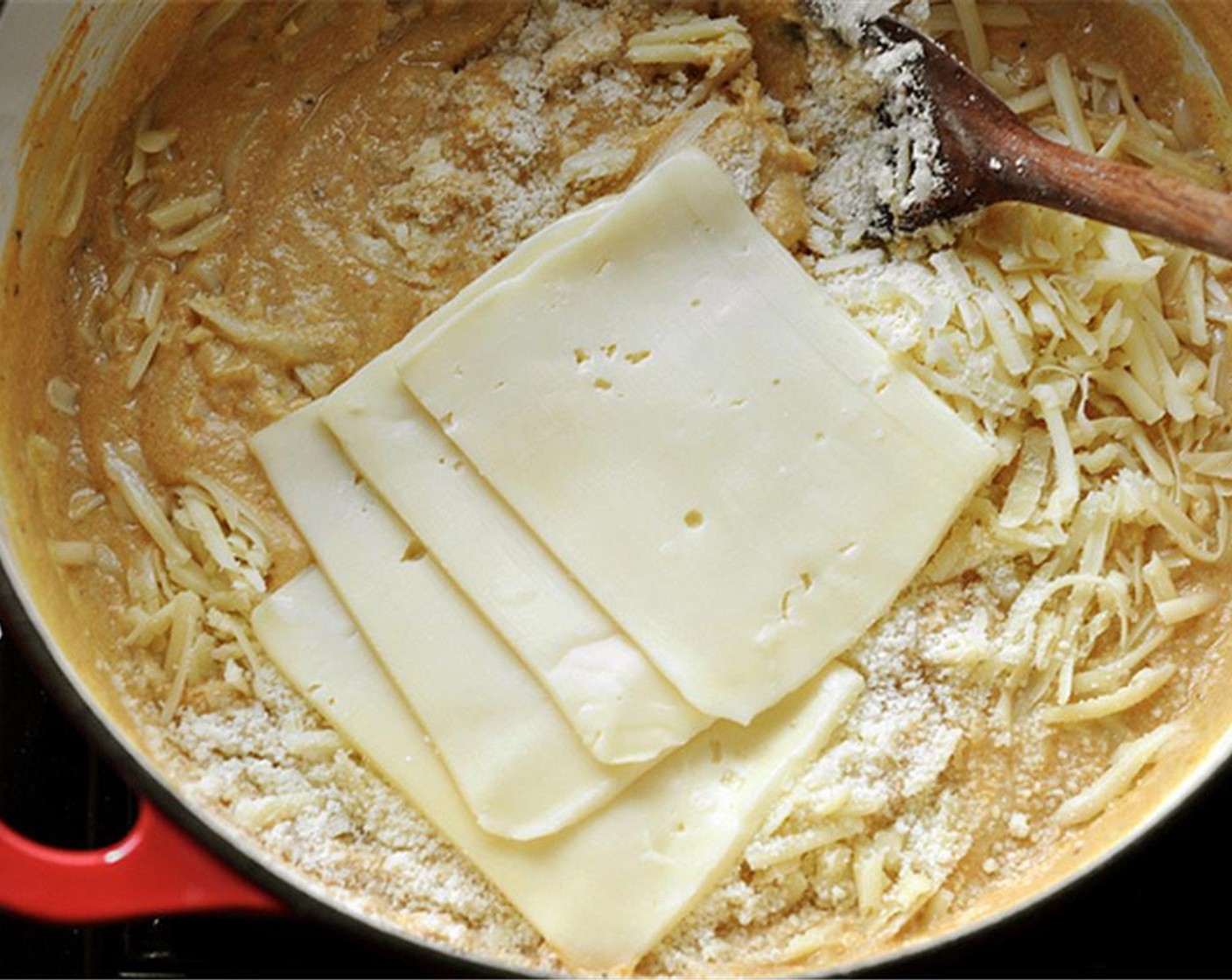 step 7 Turn off the heat and add the Cheddar Cheese (2 cups) (reserve a bit for the topping), Parmesan Cheese (1/2 cup) (reserve a bit for the topping), and Fontina Cheese (4 Tbsp). Stir until the cheeses melt and the sauce is evenly incorporated together.