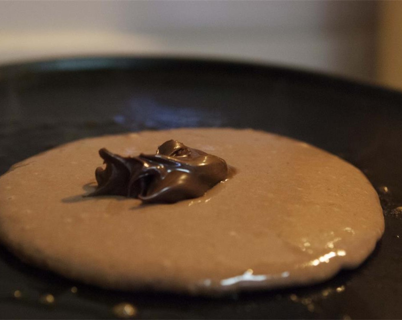 step 6 Use a 1/4 cup scoop to pour batter on the heated griddle. Spread out the pancake batter quickly and immediately scoop a large teaspoon of the Nutella® (1 2/3 Tbsp) into the middle of the raw pancake.