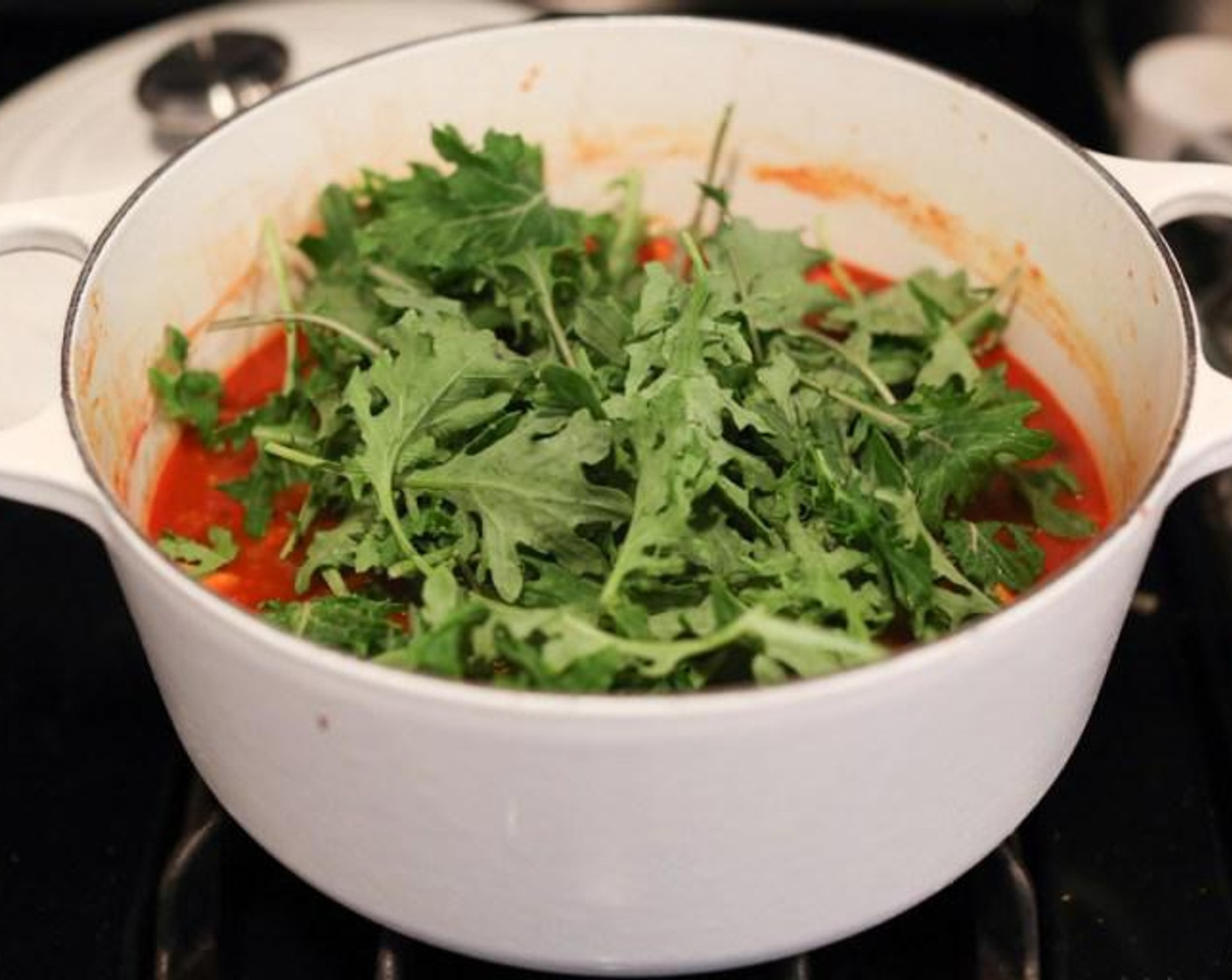 step 5 Stir in the Baby Kale (4 cups) or spinach and the Lime (1/2) and cook just until the greens have wilted. Taste and season with extra salt if necessary. Ladle the stew into bowls, garnish with Goat Cheese (3 2/3 Tbsp), Fresh Cilantro (to taste), and Tortilla Chips (to taste).
