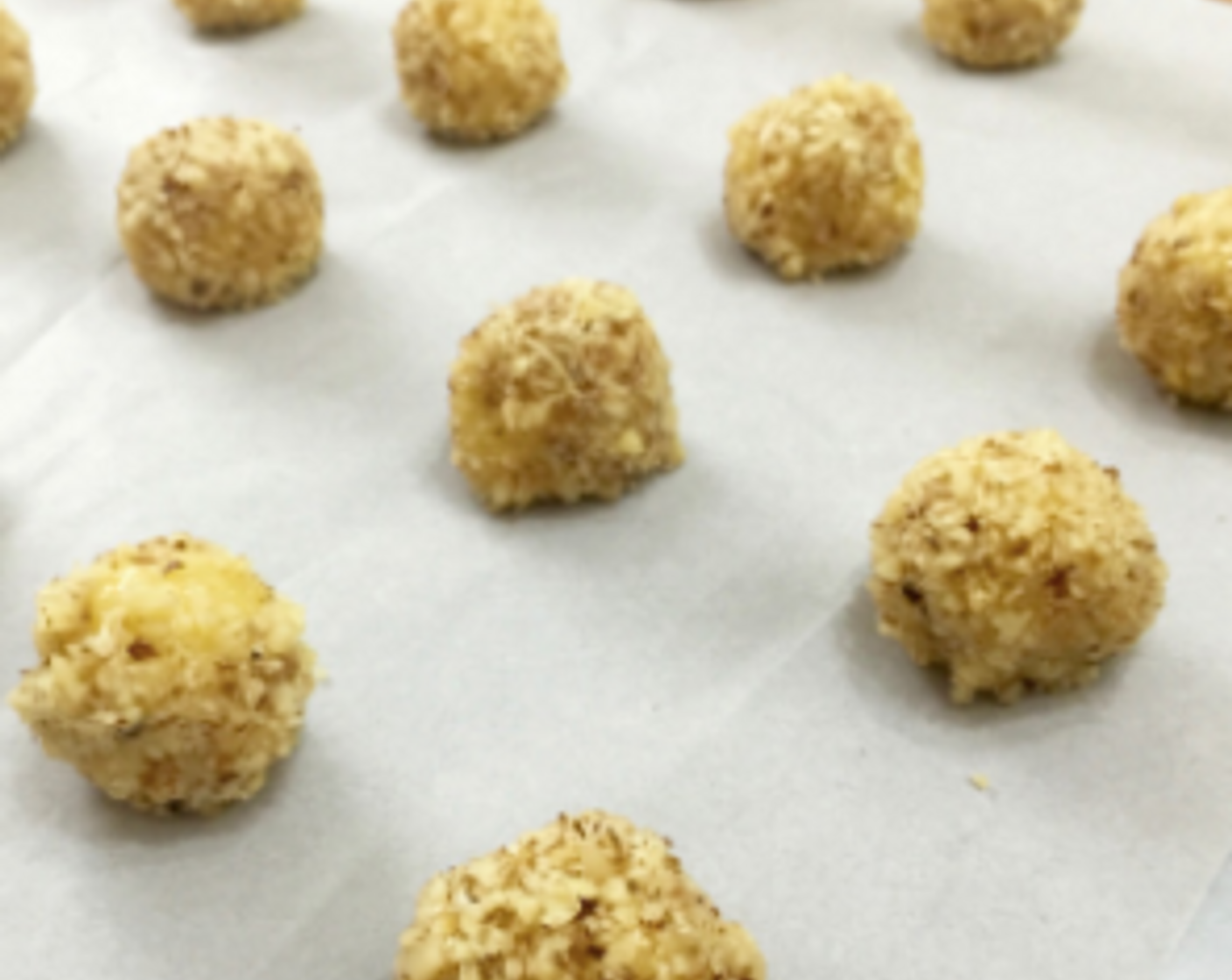 step 22 Then, put the rolled ball on the lined baking sheet. Continue to do the same for the rest of the dough balls. Evenly space them on the baking sheet.