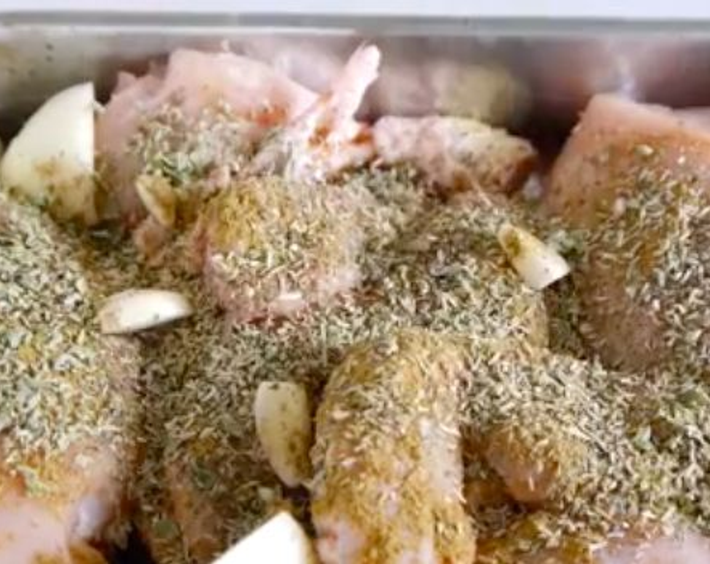 step 2 In a baking tray place the Whole Chicken (1), Dried Basil (3 Tbsp), Ground Cumin (1 Tbsp), Dried Rosemary (3 Tbsp), Worcestershire Sauce (3 Tbsp), Dried Oregano (2 Tbsp), Onion (1), Garlic (5 cloves), Salt (to taste), and Ground Black Pepper (to taste).