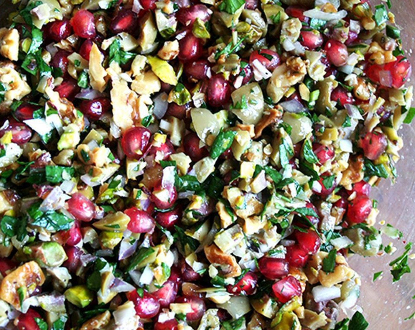 step 3 Combine Italian Flat-Leaf Parsley (1 Tbsp), Serrano Chili (1), Shallots (2), Shelled Unsalted Pistachios (4 Tbsp), Green Olives (1/2 cup), Lemon (1/2), walnuts, Pomegranate Seeds (1/2 cup), Extra-Virgin Olive Oil (1 Tbsp), Walnut Oil (1 Tbsp), Sea Salt (to taste), Ground Black Pepper (to taste) in a large bowl and toss gently.