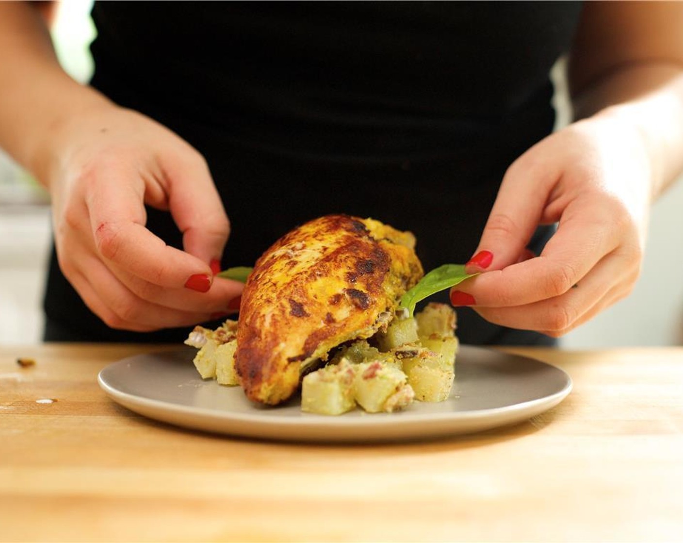 step 23 Add a scoop of the no-tato salad in the center of two plates. Lay the chicken breast on top of the salad. Garnish with basil leaves.