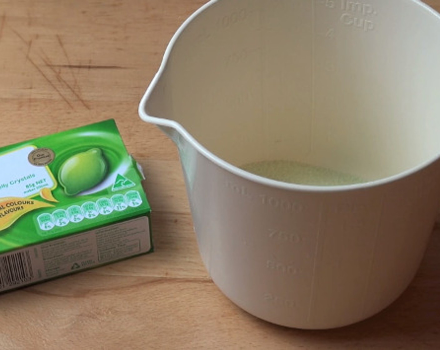 step 1 To a heatproof container, add the pack of Lime Gelatin (3/4 cup), followed by the Water (1 cup). Give the mixture a stir with a spoon until the crystals have completely dissolved.